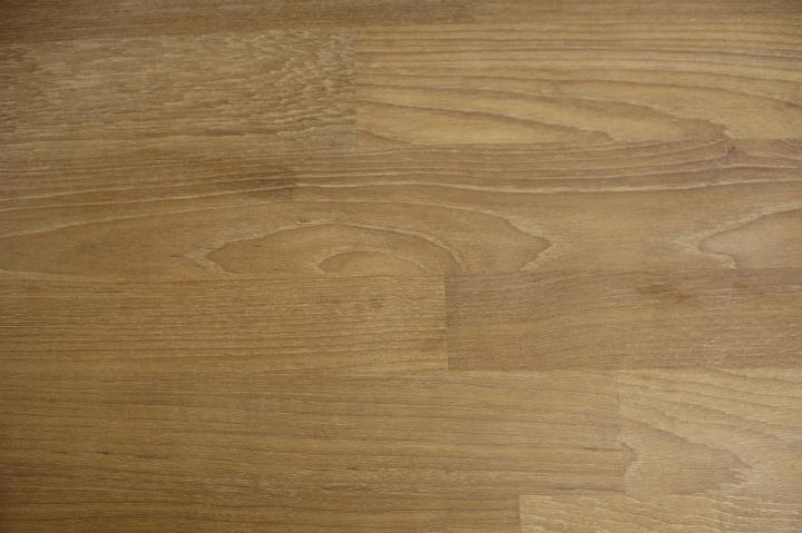 Brown parquet flooring made of horizontal rows of laminate wooden battens, close up