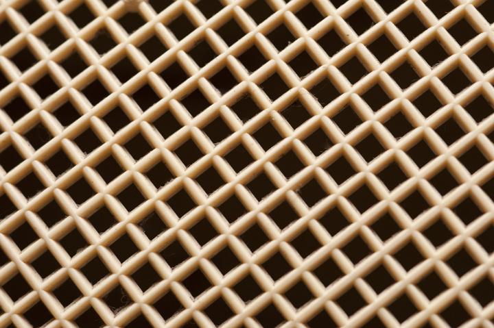 Plastic diamond mesh or grid with a geometric lattice pattern in a close up full frame background view