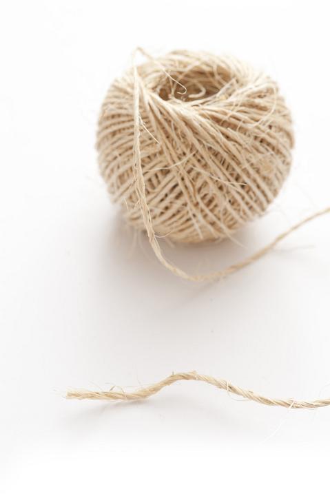 Close up Ball of off White String Isolated on White Background, Emphasizing Copy Space.