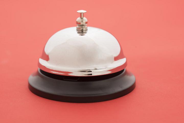 Close-up of reception bell standing against red background