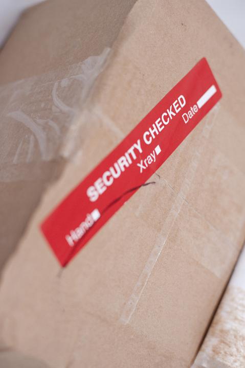 Close up Brown Cardboard Box with Red Security Label Sticker.