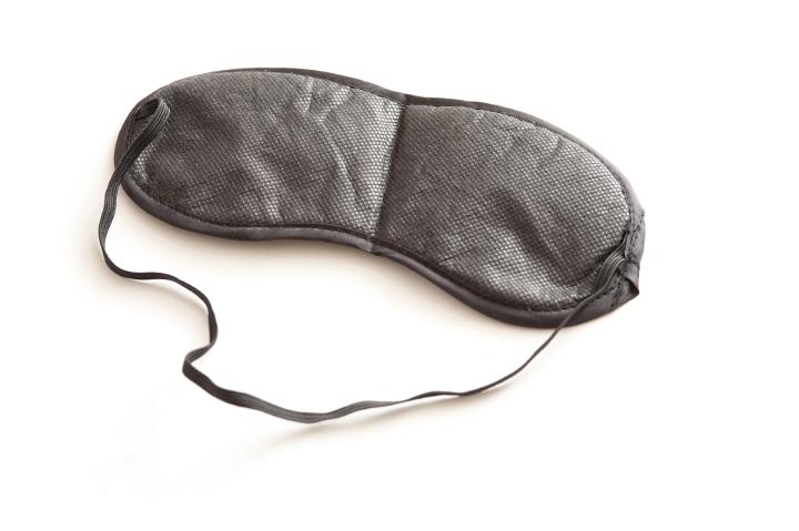 Still Life View of Single Black Sleep Mask from Above on White Background