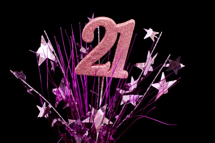 21st Celebration Conception - Close up Pink 21 Number with Purple Starburst. Isolated on Black Background.