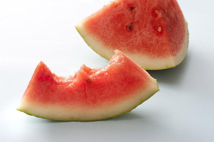 Half eaten slice of fresh juicy watermelon viewed low angle standing upright for a tasty refreshing summer treat