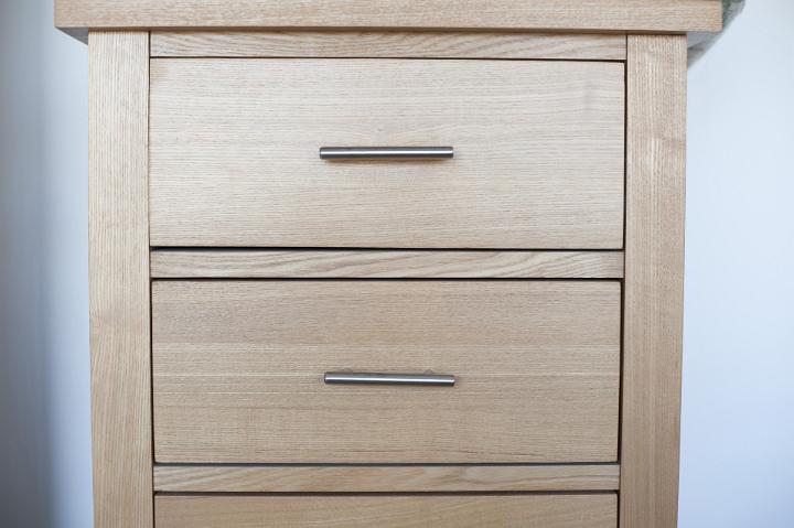 Close Up of Upright Wooden Chest of Drawers with Metal Handles