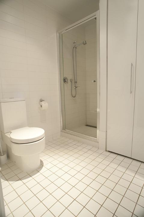 Close up Modern White Architectural Spacious Home Bathroom Design with Tiled Floor.
