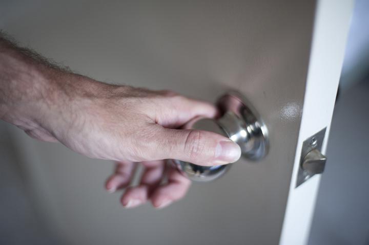 Close up Bare Man Hand Holding the Silver Knob While Opening the Room Door Slowly