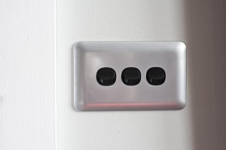 Close up Black and Gray Switches Attached on White Wall Horizontally
