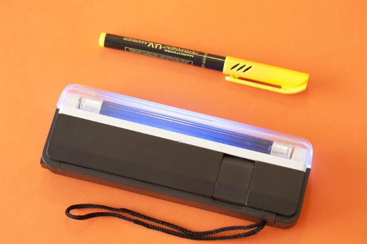 Close up Set of Modern Ultraviolet Light Marker Device Isolated on Orange Background