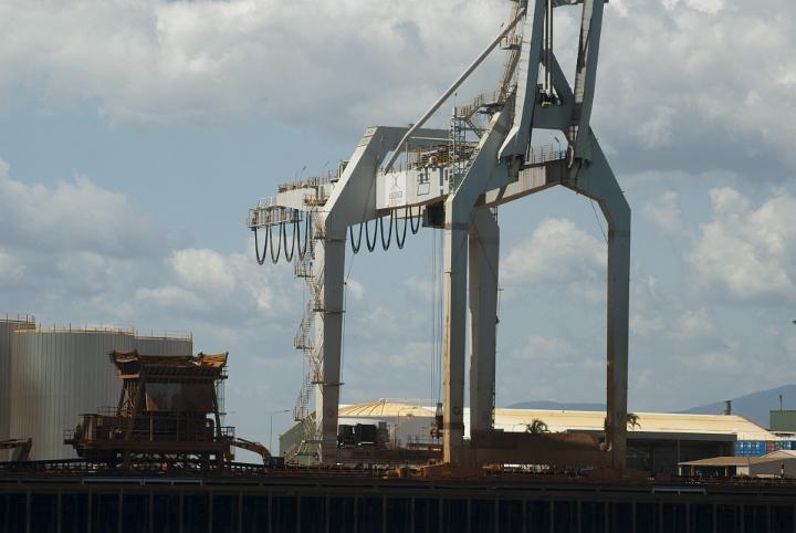Industrial cranes at a cargo depot standing on the wharf ready for loading cargo onto ships at a port or harbor