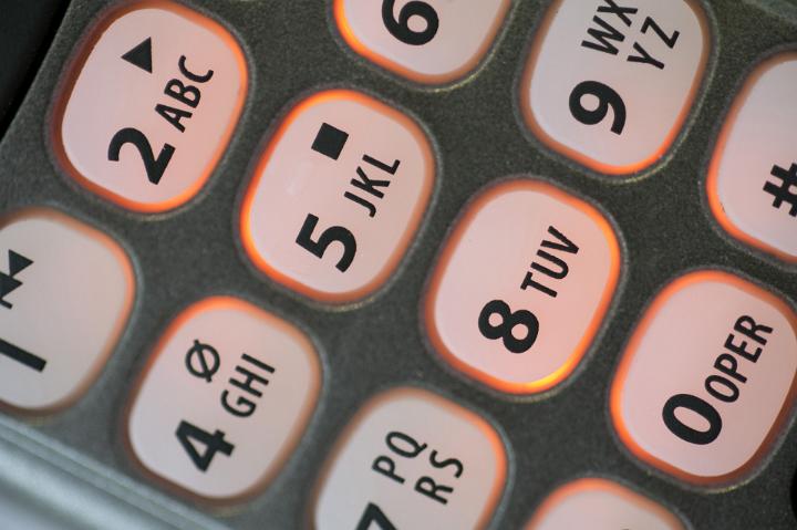 Keys and keypad on a telephone handset with numbers and alphabet letters in a communications concept, close up view