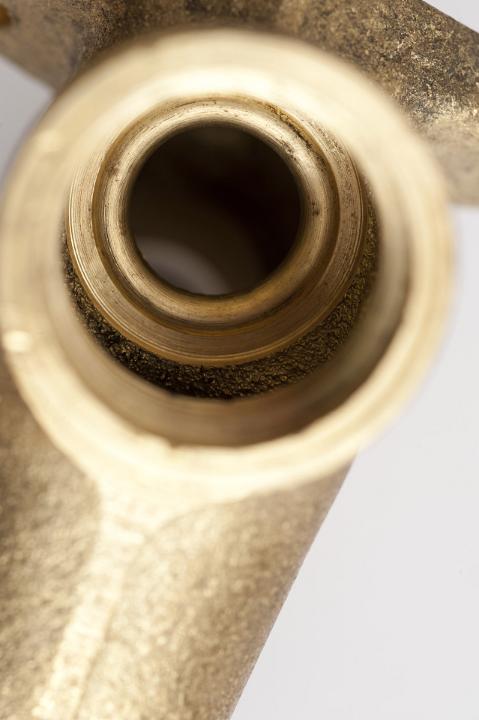 Close up detail of a tap seat or screw fitting on a brass garden tap from overhead