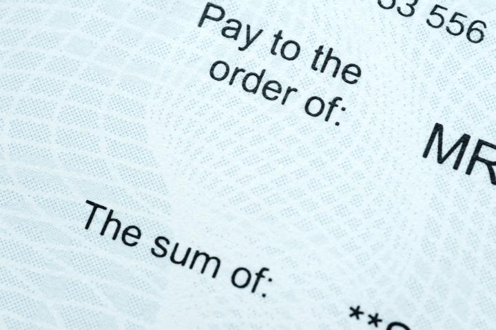 Close up Labels of a Cheque Paper Emphasizing the Name of the Payee and the Sum of the Money.