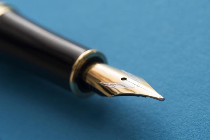 Close-up of fountain pen nib on blue background