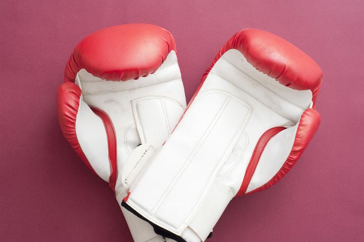 Close up Pair of Red and White Boxing Gloves for Workout Isolated on a Fuchsia Background