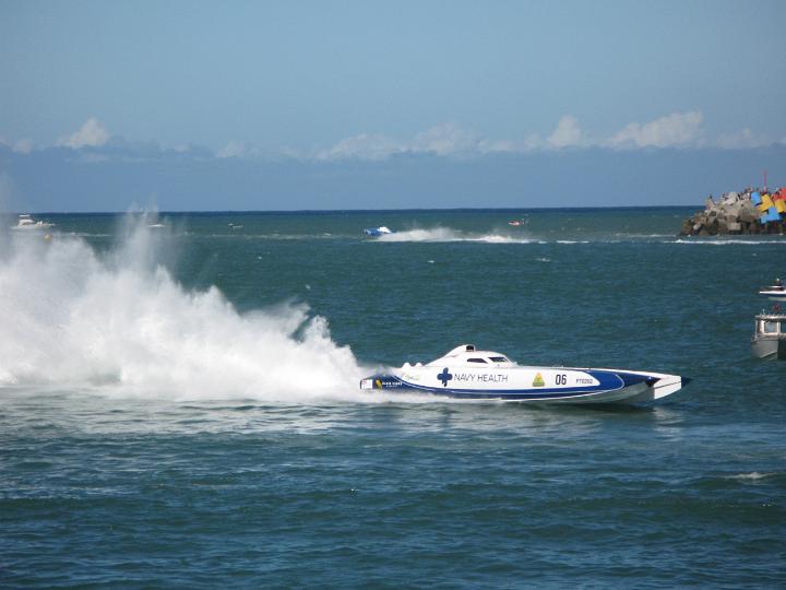 Speedboat competing in an offshore power boat race speeding past throwing up a spray of water in its wake
