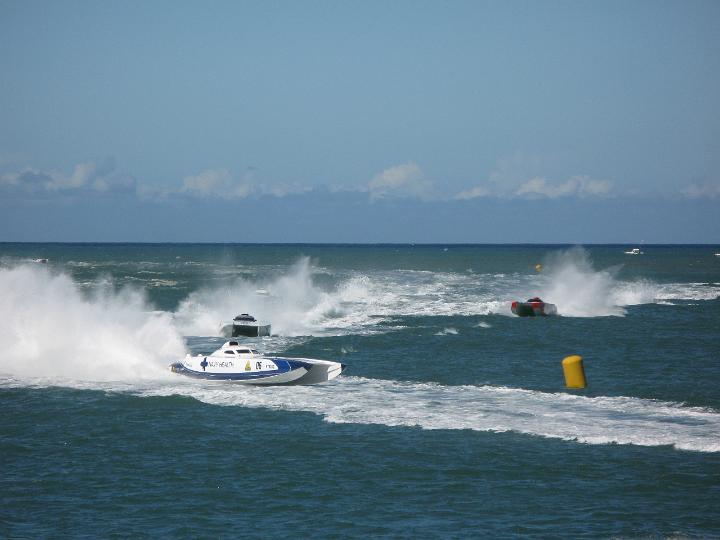 Power boat racing with competitors in speed boats rounding the marker buoys for the course at great speed in a cloud of spray from the wake