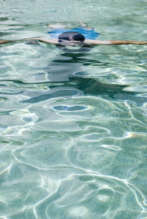 Young Active Man Swimming In Crystal Clear Sea Water on a Tropical Climate.