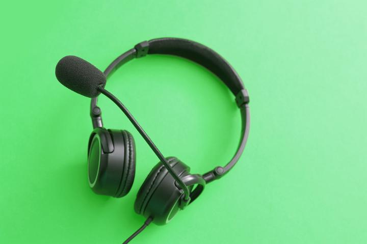 Close up Black Call Center Headset Isolated on Light Green Background.