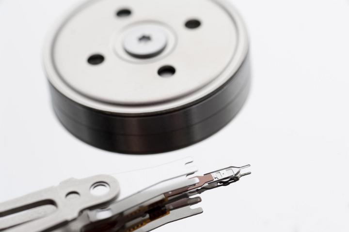A close up of the internal components and parts of a computer hard disk isolated on a white background with copy space.