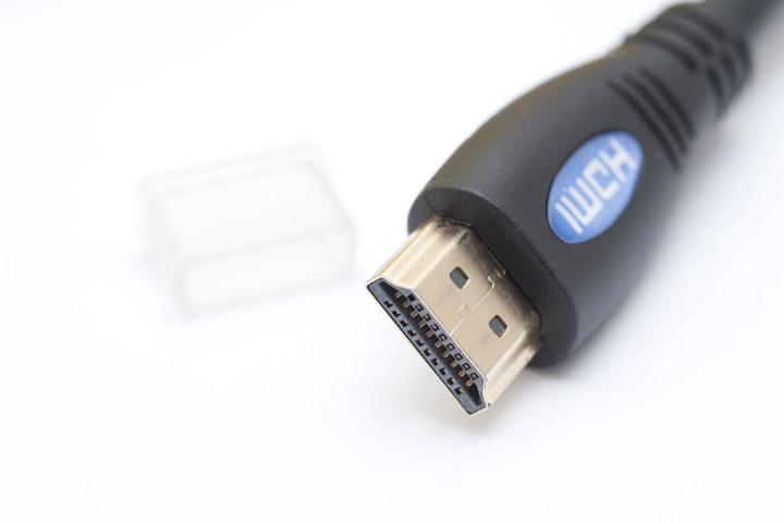 Close up detail of a HDMI, or high definition multimedia interface, connector plug for connecting to a personal computer and its plastic cover lying on a white background
