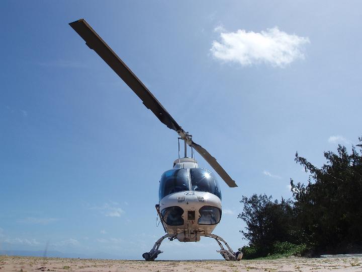 Low Angle View of Landed Helicopter on Ground with Sunny Blue Sky