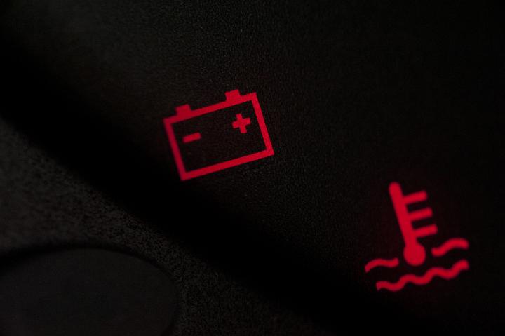 Battery and temperature or fuel warning lights illuminated in red on a vehicle display during ignition start up as the system checks for problems
