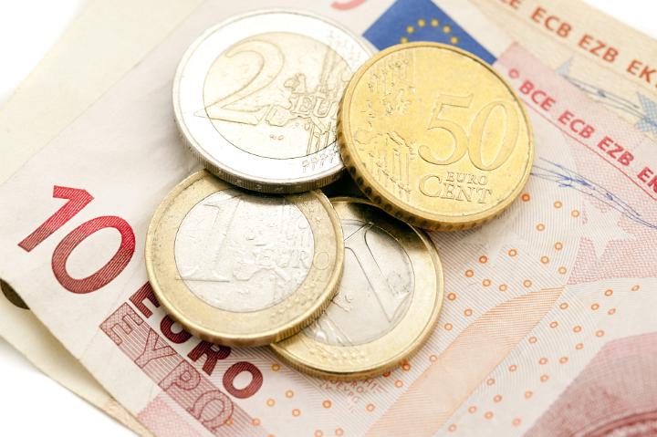 Financial background of a 10 Euro banknotes and assorted coins in a savings, payment, currency and earnings concept