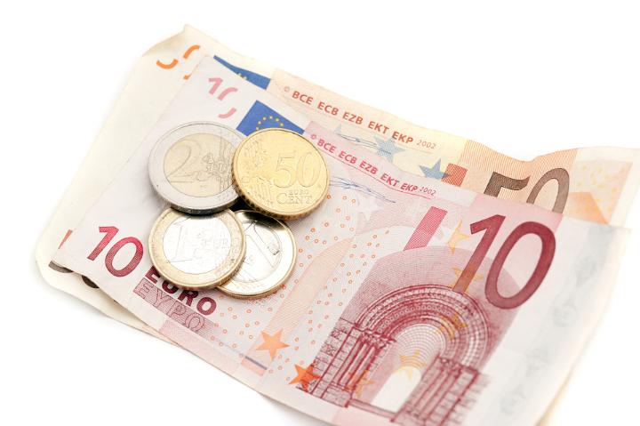 Euro 10 and 50 euro banknotes and coins lying on top of each other over a white background in a financial and currency concept