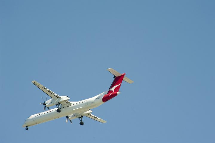 Domestic Flight - Airplane Flying Up in the Sky on Light Blue Gray Background. Emphasizing Copy Space.