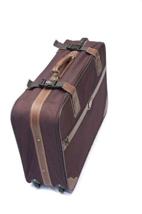 Unmarked brown suitcase, luggage or baggage, with straps and wheels conceptual of travel and vacations on white