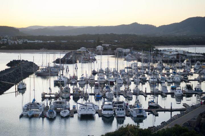 Evening view of rows of yachts moored in the calm sheltered water of a marina