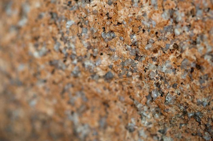 Aggregate rock texture showing the different colors and textures of the constituent minerals in a full frame close up view