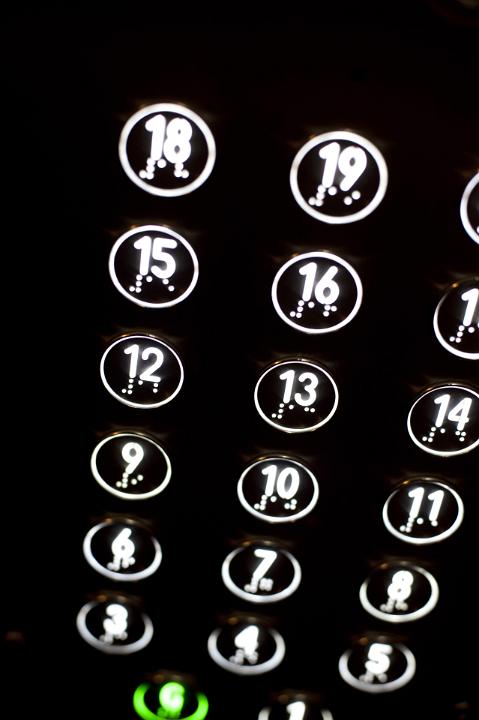 Close up Glowing White Device Buttons with Numbers on Black Background.
