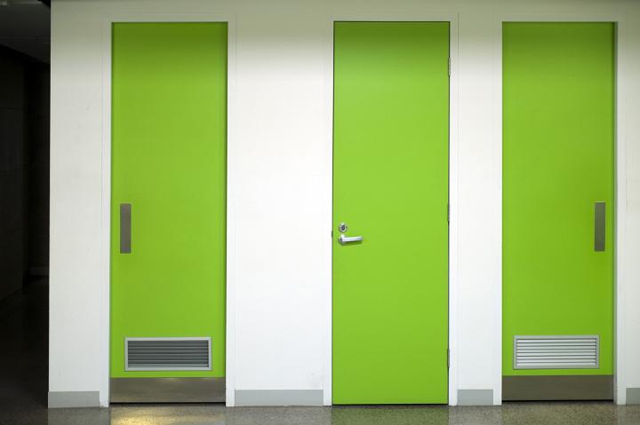 Architectural Interior Detail of White Wall with Three Closed Bright Green Doors in a Row
