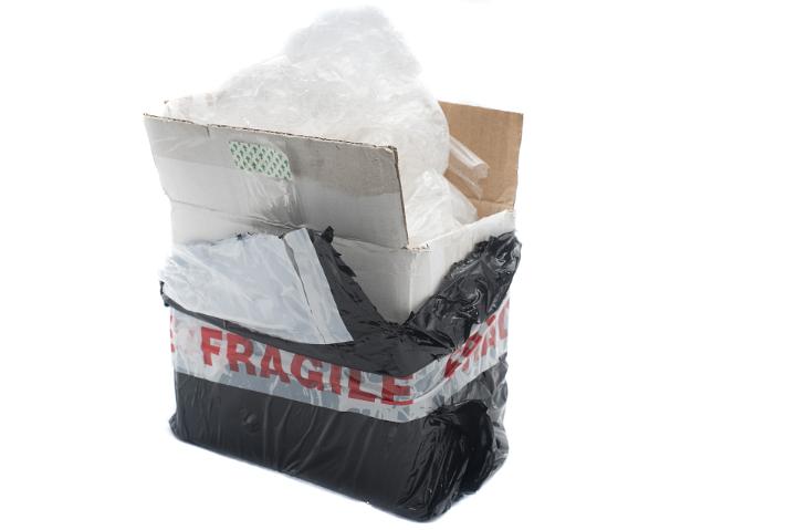 Opened cardboard box postal or courier package with fragile sticker and interior packaging isolated on white