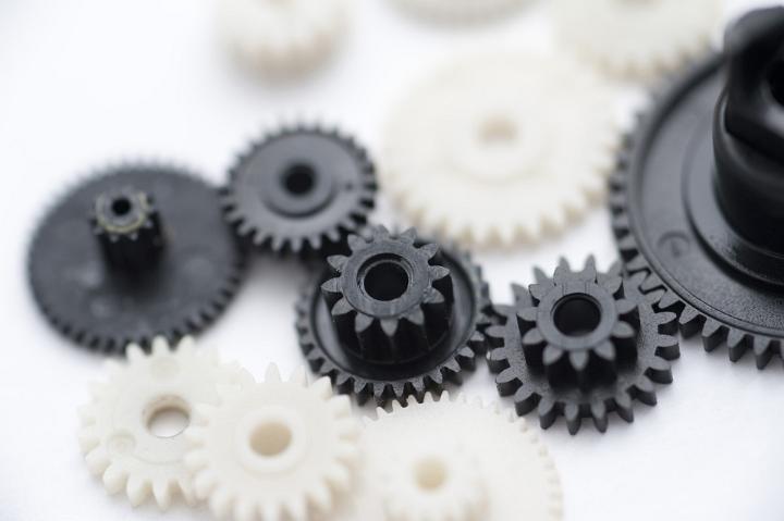 Close Up of Various Sized Black and White Plastic Gears on White Background, Business Teamwork Concept Image