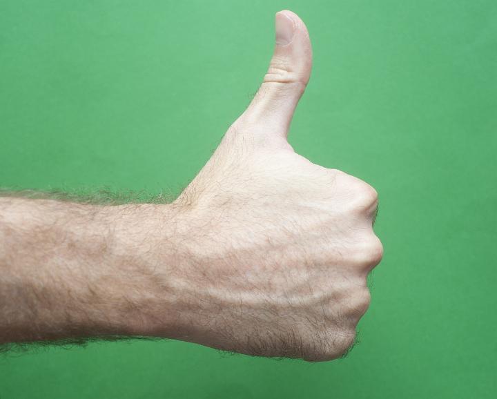 Close up Bare Hairy Man Hand Showing Thumbs Up Sign, Isolated on Green Background.