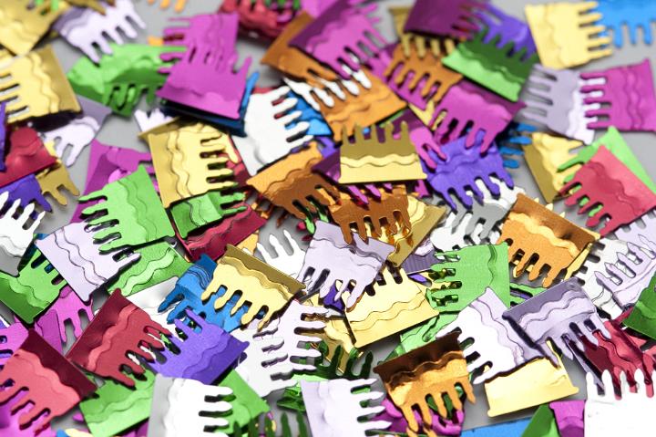 Colorful party background of paper confetti sprinkles in the colors of the rainbow to celebrate a party or carnival, full frame