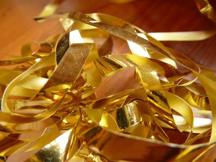 Close up Tangled Gold Foil Cuttings on Top of Wooden Table
