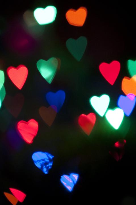 Background of colorful heart-shaped party lights glowing in the darkness at a special event, wedding or Christmas