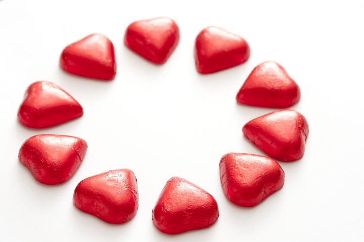 Ten bright red valentine hearts arranged in a circle isolated on a plain white background.