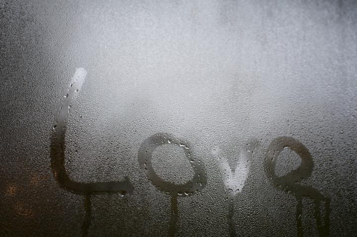 Close up Love Texts on Misty Glass Window for Backgrounds, Emphasizing Copy Space.