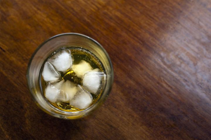Looking Down into Cocktail Glass with Beverage on the Rocks on Wooden Table