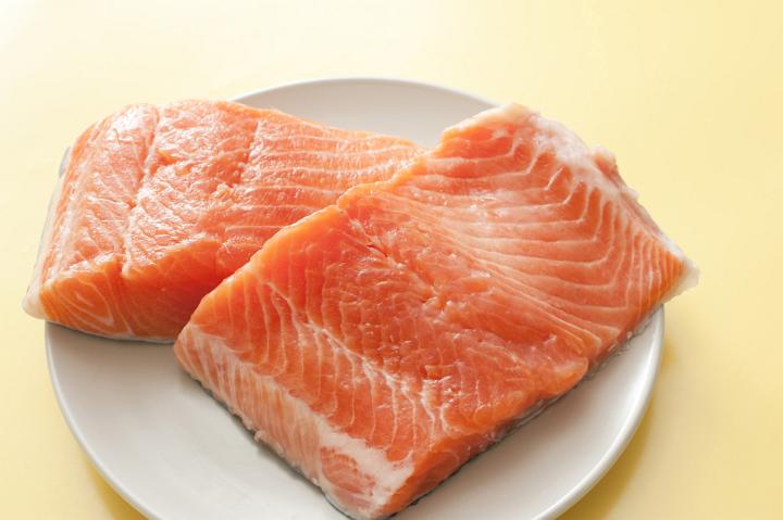 Two fresh raw salmon fillets on a plate ready to be cooked for a gourmet seafood meal, high angle view