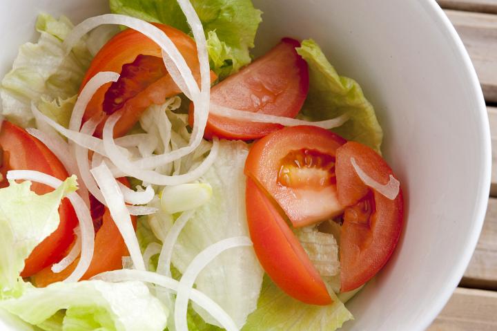 Close up Fresh Vegetable Salad on White Bowl with Cabbage, Lettuce and Tomatoes