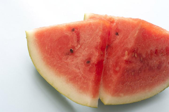A sliced and quartered fresh, juicy watermelon isolated on a white background with copy space.