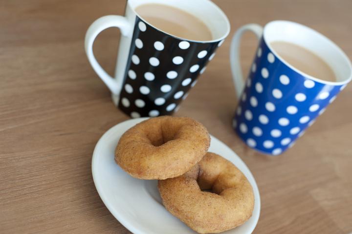 Close up Cups of Tea and Sweet Doughnuts on Plate Served on Top of Wooden Table