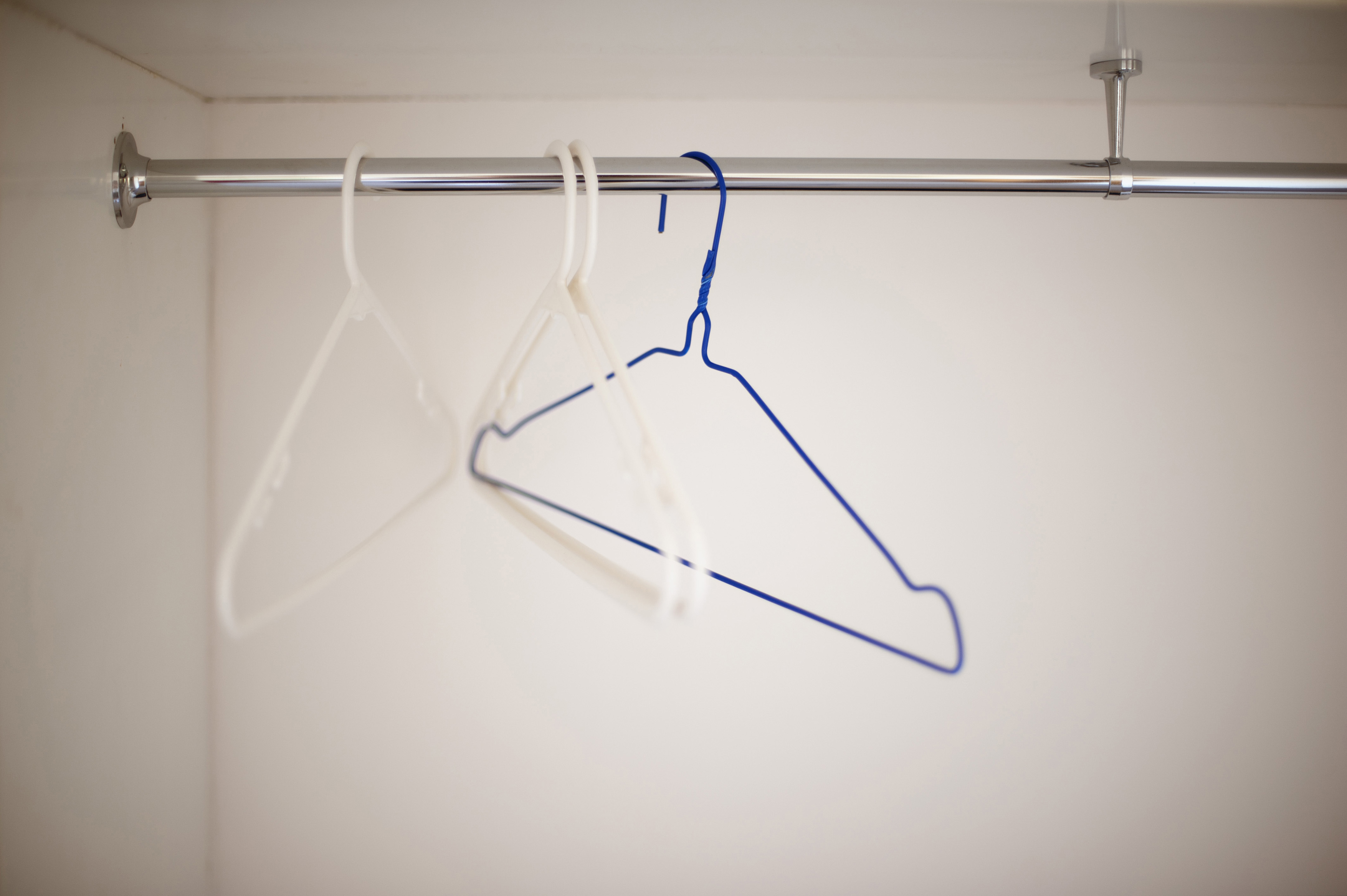 Wire coat hangers on a clothing rail. 