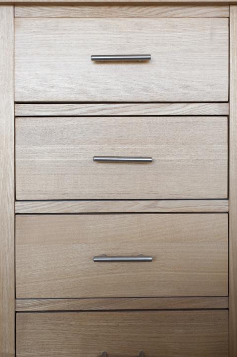 Close up full frame view of a small natural wood chest of drawers for household storage